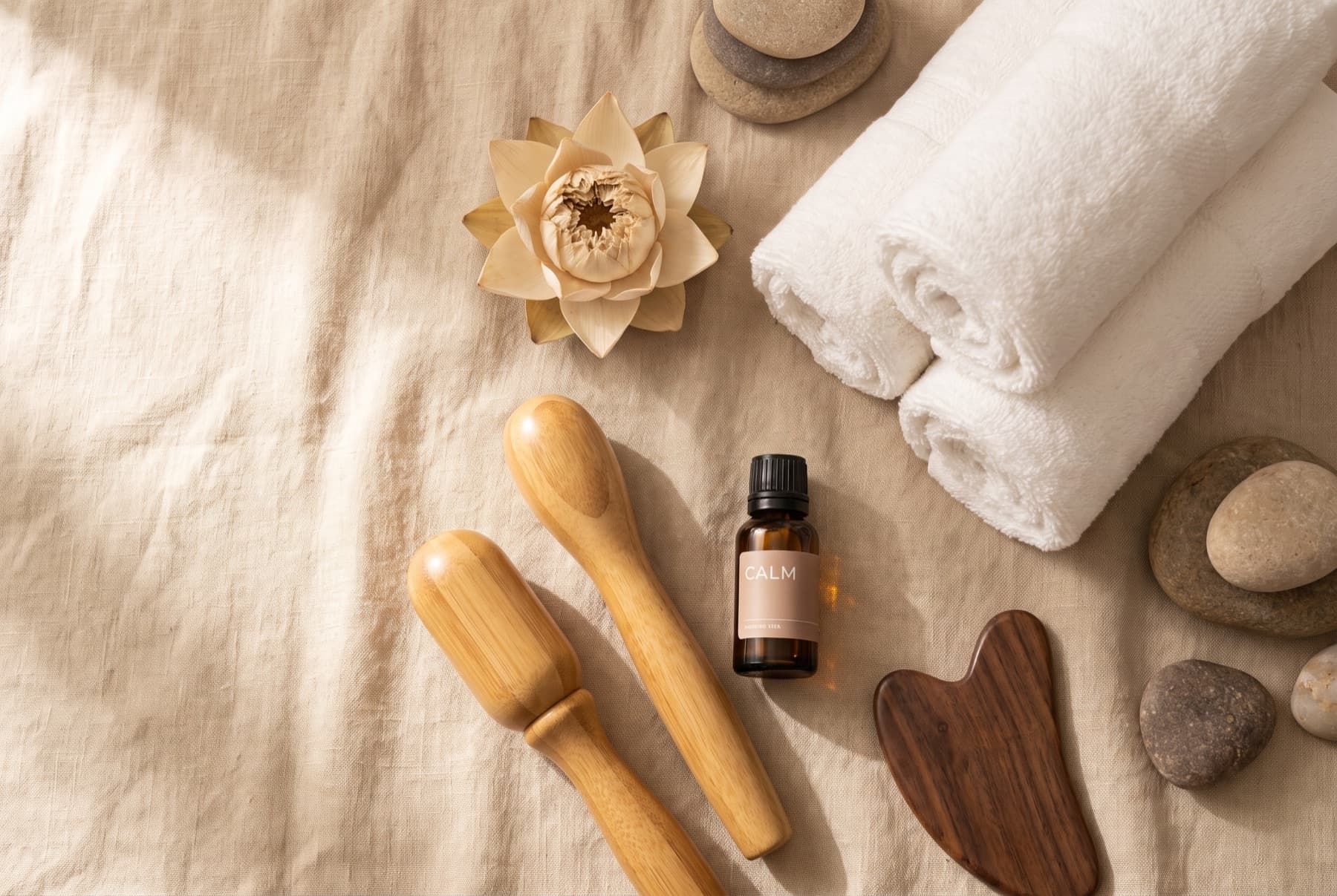 Spa essentials: rolled towels, oils and smooth stones